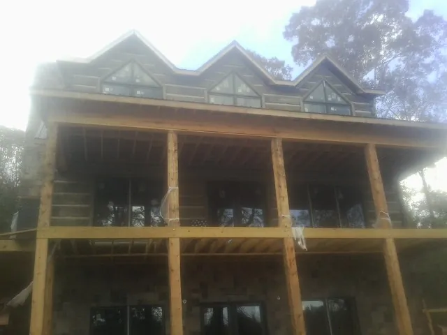 Dormers and porch framing on a large log home under construction — Roof Coating work by our crew in Minersville